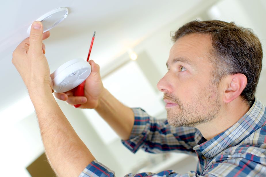 man installing a smoke detector for the Smoke Detector Mandate